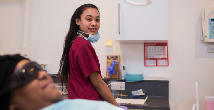 Dentistry nurse smiling while the patient is sitting patiently.
