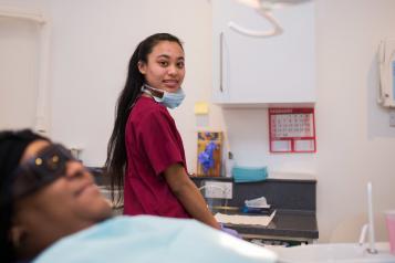 Dentistry nurse smiling while the patient is sitting patiently.