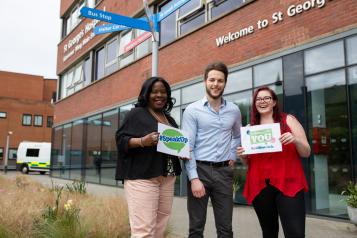 Group of Healthwatch volunteers outside a hospital holding 'Speak up' sign