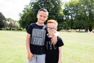 Two boys together, smiling at the camera