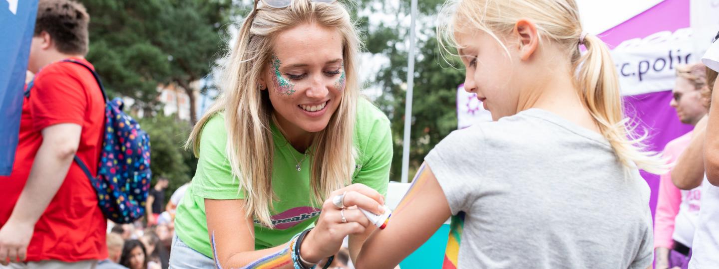 Image of a Healthwatch volunteer applying a colourful plaster onto a child's arm at an event