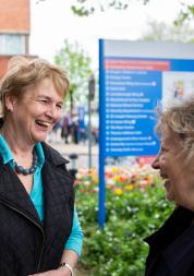 Two older women talking outside of a hospital